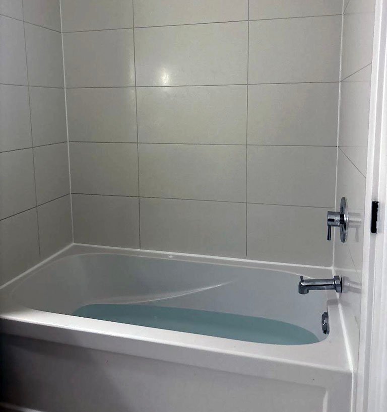 Handyman applying silicone caulking to bathroom and kitchen surfaces in Toronto GTA homes